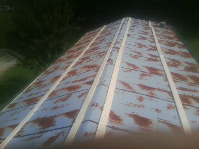 Rusted metal roof panels with new wood purlins before replacement — Storm Damage Roof Repair in Imlay City by Roofing Brothers